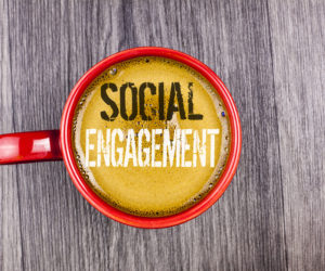 Writing note showing Social Engagement. Business photo showcasing post gets high reach Likes Ads SEO Advertising Marketing written Coffee in Red Cup the Grey wooden background. Top view.