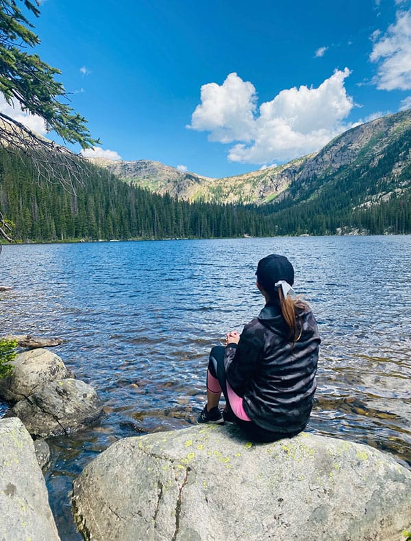 Kim sitting by mountain lake